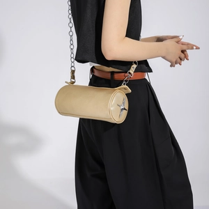 Detail of champagne gold cylindrical bag with silver star hardware and chain strap