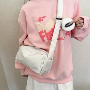 Detailed macro view of white matte leather crossbody bag with small round coin purse attachment