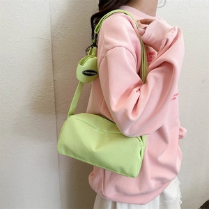 Detail of light green crossbody bag with matching circular coin purse on strap