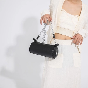 Detail of black cylindrical PU crossbody bag with silver cross star and metal chain strap