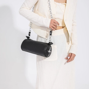 Detail of black cylindrical crossbody bag with silver star ornament and chain strap