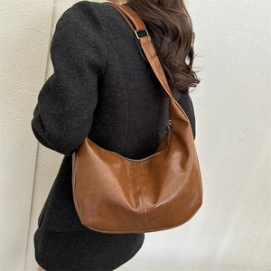 Detail view of cognac brown hobo shoulder bag with silver metal ring and premium PU texture