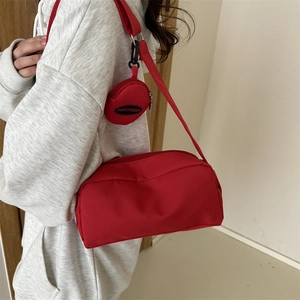 Detail of red nylon crossbody bag with a detachable small round coin purse charm