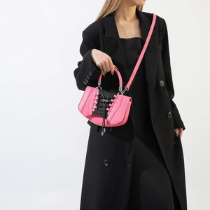Detail of pink and black crossbody bag featuring unique sneaker-style lace-up design element