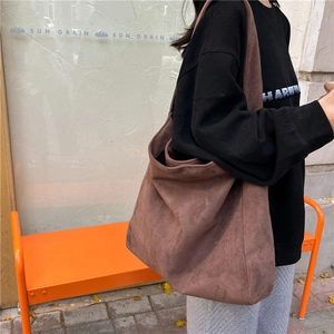 Macro shot of dark brown woolen crossbody bag with wide strap for daily commute