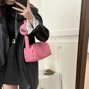 Detail of pink nylon crossbody bag with a round coin purse on the wide strap