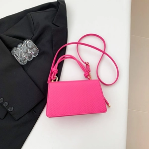 Dettaglio ravvicinato della borsa rosa neon con trama a grana e finiture metalliche dorate