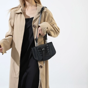 Detail of black crossbody bag with corset-style lacing and matte leather finish