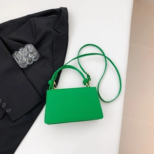 Dettaglio borsa verde brillante trama litchi con manico annodato e hardware dorato