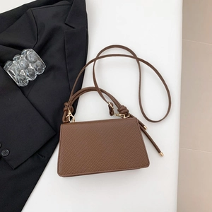 Dettaglio della borsa marrone in finta pelle martellata con eleganti finiture in metallo