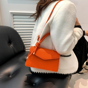 Elegante borsa a tracolla in pelle arancione brillante con manico annodato da donna