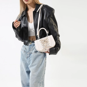 Detail view of cream white PU handbag featuring corset-style lace-up design and metal eyelets