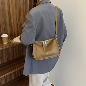 Close-up of vintage brown PU leather crossbody bag with golden hardware and zipper detail