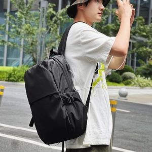 Detail of minimalist nylon backpack showing side USB charging port and adjustable side strap