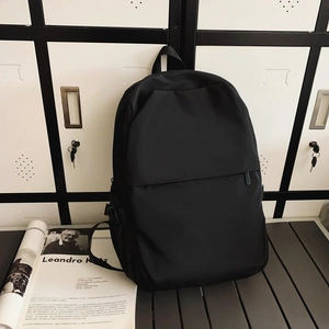 Detail view of a black nylon backpack featuring matte finish and hidden front zipper pocket
