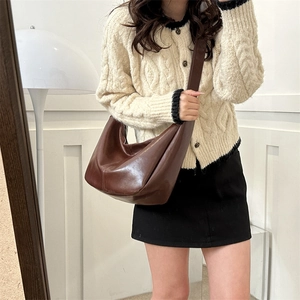 Close-up of brown hobo bag showing retro leather texture and integrated wide strap
