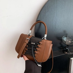 Detailed close-up of brown PU handbag featuring vintage corset-style lace-up buckle design