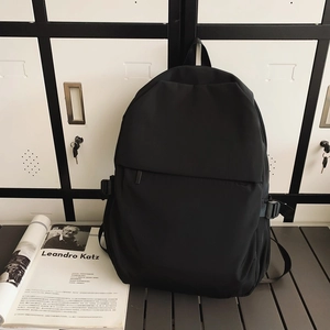 Detail of minimalist black nylon backpack with side buckle and hidden zipper pocket