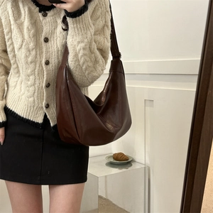 Detail of dark brown hobo shoulder bag showing moon shape and premium PU leather texture