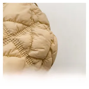Detailed close-up showing beige quilted fabric and soft padded texture on the handbag