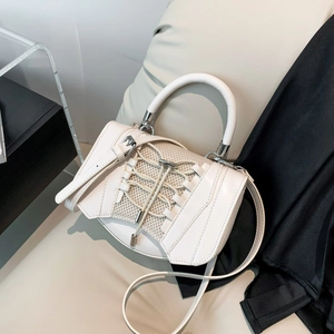 Detailed macro view of white cross-laced handbag with mesh texture and silver hardware