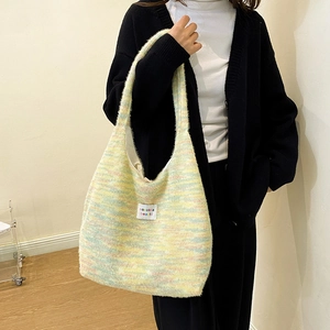 Detailed close-up of a multicolor knit tote bag with macaron pastel shades and woven label