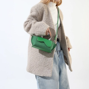 Green shoulder bag with silver curved metal handle and asymmetric geometric silhouette