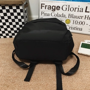 Detail view of black nylon backpack with adjustable straps and water-resistant fabric