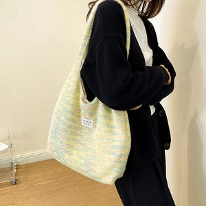 Detail of soft knit tote bag with colorful blended fibers and Szakka beaute woven label