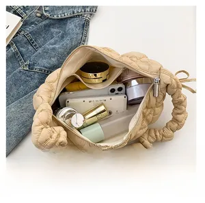 Spacious interior of beige quilted cloud bag showing phone and cosmetics storage