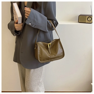 Detail view of premium dark brown PU leather crossbody bag with textured finish and golden zipper