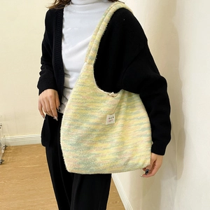 Detail of colorful knitted mohair tote bag with horizontal pastel stripes and logo patch