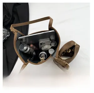 Top view of brown leather bucket bag showing large interior capacity with gadgets