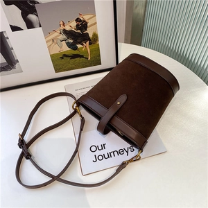 Top view of dark brown bucket bag featuring suede and leather texture with metal buckle