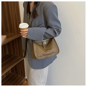 Detail of vintage brown PU leather crossbody bag with double zippers and retro matte finish