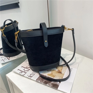 Detailed close-up of a black matte PU bucket bag with gold hardware and smooth leather trim