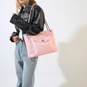 Détail du sac rose brillant en PU avec bandoulière chaîne argentée et fermoir rotatif