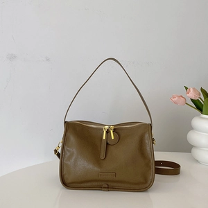 Detail view of smooth matte PU leather shoulder bag with golden dual zippers and charm