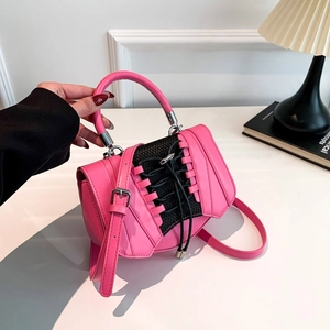 Detail of pink PU leather handbag featuring black corset lace-up design and round handle