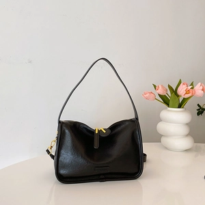 Close-up of black PU leather bag showing gold zippers and Fashion & Sport tag details