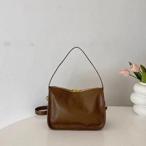 Detail view of premium dark brown PU leather bag with golden dual zippers and textured finish