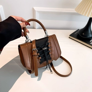 Detail view of brown PU leather handbag with black mesh weaving and lace-up design