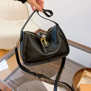 Detail of minimalist black lychee texture PU leather bag with premium gold hardware