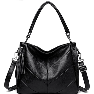 Minimalist black herringbone crossbody bag with tassel detail and adjustable strap