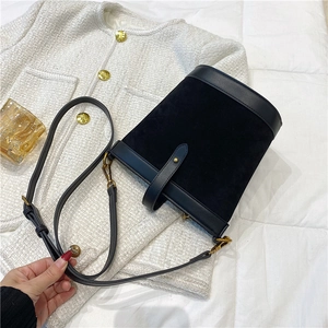 Detail view of black PU bucket bag with suede texture, gold hardware and leather strap