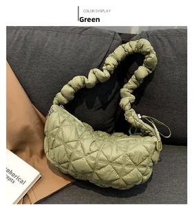 Detail view of the green quilted fabric surface and scrunched handle on this shoulder bag