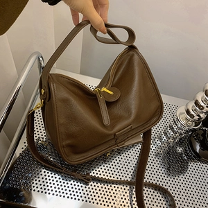 Detailed shot of dark brown soft PU leather texture on a minimalist crossbody bag