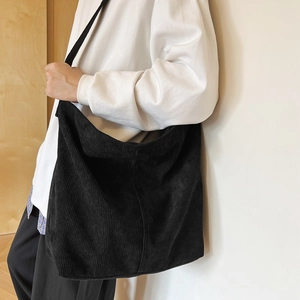 Dettaglio di una borsa tote in velluto a coste nero con trama del tessuto in vista