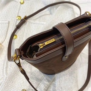 Detail of dark brown suede bucket bag with BNLP engraved zipper and golden hardware