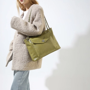 Détail du sac bandoulière vert en cuir PU brillant avec fermoir pivotant et chaîne argent